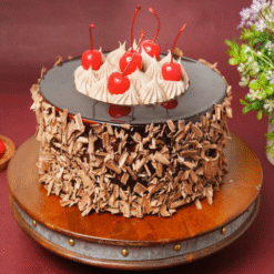 Classic Black Forest Cake topped with cherries and chocolate curls